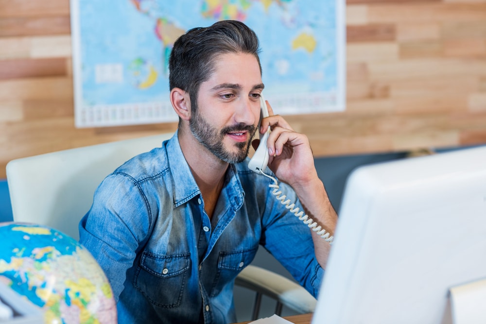 Travel agent working on the phone in an office